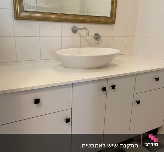 משטח שיש לבן עם כיור עגול בחדר אמבטיה